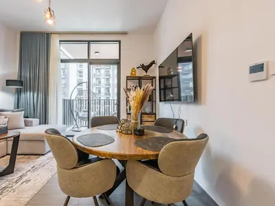 a dining room with a table and chairs at Modern & Luxury 1BR -Pool View - Kensington Waters in Dubai