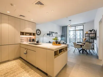 a kitchen with white cabinets and a dining room at Modern & Luxury 1BR -Pool View - Kensington Waters in Dubai