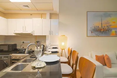 a kitchen with a table and chairs and a kitchen with a kitchen at 3BR Marina view apartment in JBR Close to Tram & Metro in Dubai