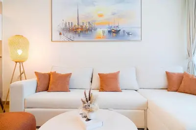 a living room with a white couch and a painting at 3BR Marina view apartment in JBR Close to Tram & Metro in Dubai