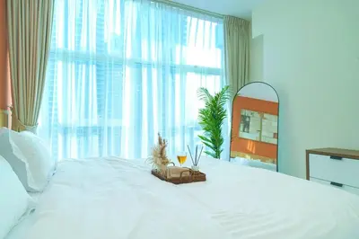 a bedroom with a white bed with a large window at 3BR Marina view apartment in JBR Close to Tram & Metro in Dubai