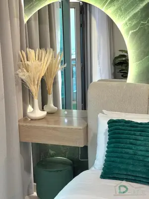 a bedroom with a bed and a table with vases at 1 BR Apartment in Downtown Dubai in Dubai