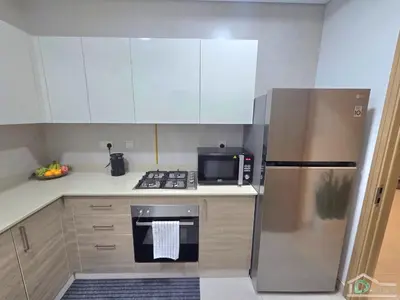 a kitchen with a stainless steel refrigerator and a microwave at 1 BR Apartment in Downtown Dubai in Dubai