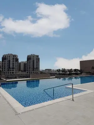 a large swimming pool with buildings in the background at Brand new and stylish 2BR with stunning views - Creek Palace in Dubai