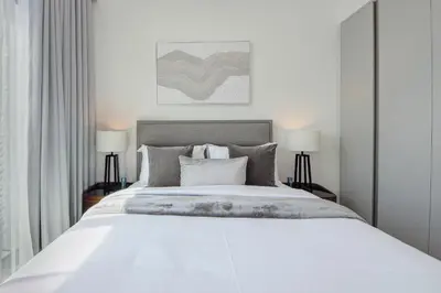 a bedroom with a large white bed with two lamps at Brand new and stylish 2BR with stunning views - Creek Palace in Dubai