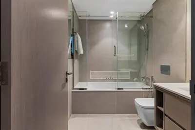 a bathroom with a shower and a toilet and a sink at Burj Khalifa View 2 BR Apartment w Parking in Dubai