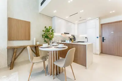 a kitchen with a table and chairs in a room at Community Views 1BR Next to Mall and Park, Binghatti Amber, Jumeirah Village Circle by Deluxe Holiday Homes in Dubai