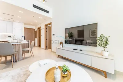 a living room with a large tv on the wall at Community Views 1BR Next to Mall and Park, Binghatti Amber, Jumeirah Village Circle by Deluxe Holiday Homes in Dubai