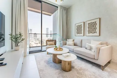 a living room with a couch and a table at Community Views 1BR Next to Mall and Park, Binghatti Amber, Jumeirah Village Circle by Deluxe Holiday Homes in Dubai