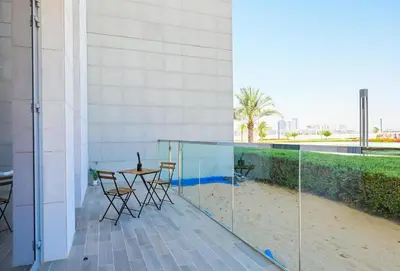 a balcony with a table and chairs in a building at Crystal Escape 1BR Lagoon Access in Dubai