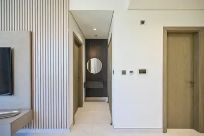 a hallway with a door and a mirror at Crystal Escape 1BR Lagoon Access in Dubai