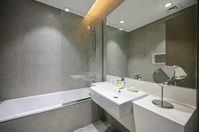 a bathroom with a white sink and a mirror at Crystal Escape 1BR Lagoon Access in Dubai