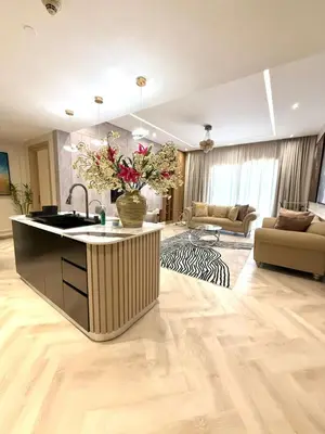 a kitchen with a sink and a living room at Cozy, Fully Fitted Smart Home in Dubai