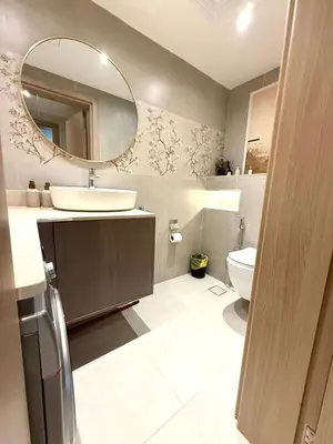 a bathroom with a sink and a mirror and a toilet at Cozy, Fully Fitted Smart Home in Dubai