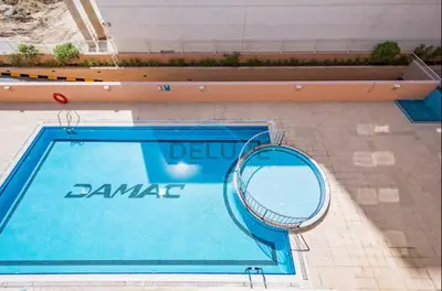 a swimming pool with a tennis racket next to it at Cozy, Fully Fitted Smart Home in Dubai