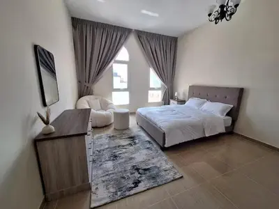 a bedroom with a bed and a tv and a window at ARS vacation homes rental in Dubai