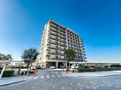 a tall building with a parking lot in front of it at ALiving Elegant 1BR Apartment with Balcony I MAG960 in Dubai