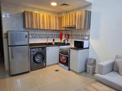 a kitchen with a stove and a washer and dryer at ARS vacation homes rental in Dubai