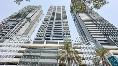 two tall buildings with palm trees in front of them at Modern Fully Furnished Apartment in Bloom Tower B JVC - Easy Access to JBR, Circle Mall & Dubai Hills Mall in Dubai