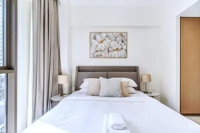 a bedroom with a large white bed with two lamps at GuestReady - Modern design in Dubai Creek Harbour in Dubai