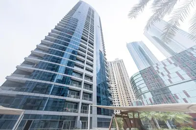 a tall building with a palm tree in front of it at Stylish place with Breathtaking Marina Views in Dubai