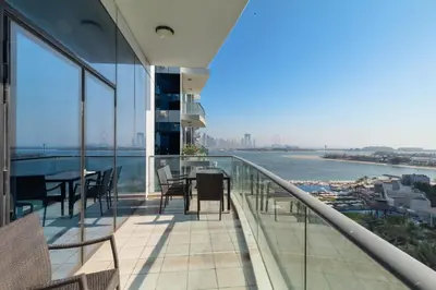 a balcony with a table and chairs on a building at Modern 1BD, beautiful SeaView, Pool & Beach access in Dubai