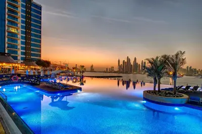 a large swimming pool with a city in the background at Modern 1BD, beautiful SeaView, Pool & Beach access in Dubai