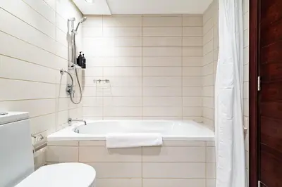a white bathroom with a tub and a toilet at Vibrant 2BR in Burj Views - Near Dubai Mall & Burj in Dubai