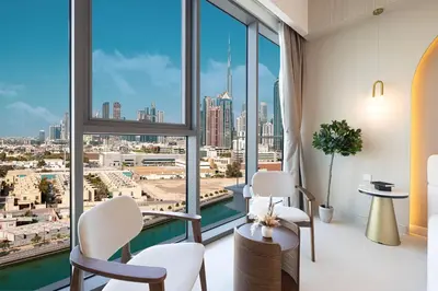 a room with a large window with a view of a city at Luxury Canal Front with Burj Khalifa Skyline View in Dubai