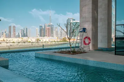a pool of water with a city in the background at Luxury Canal Front with Burj Khalifa Skyline View in Dubai