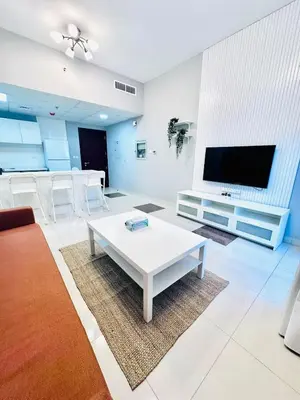 a living room with a white table and a flat screen tv at Vibrant Marina Retreat! in Dubai
