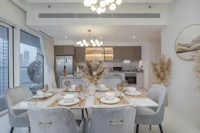 a dining room with a table and chairs at Grand Bleu I Private Beach I Palm Jumeirah, Sea & Sky Views I Infinity Pool I PS5 I by Skyline Serenity in Dubai