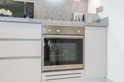 a kitchen with a stainless steel oven with a microwave at Grand Bleu I Private Beach I Palm Jumeirah, Sea & Sky Views I Infinity Pool I PS5 I by Skyline Serenity in Dubai