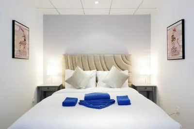 a bedroom with a white bed with blue towels on it at Stylish 1BR plus study room with Queen bed in Dubai