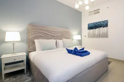 a bedroom with a white bed with a blue bow on it at Stylish 1BR plus study room with Queen bed in Dubai