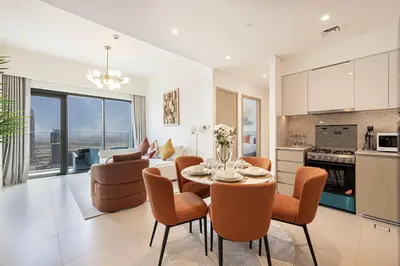 a kitchen and living room with a table and chairs at Lux apartment with full Burj View - 5 min walk to Dubai Mall in Dubai