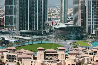 a view of a city with a building and a flag at Lux apartment with full Burj View - 5 min walk to Dubai Mall in Dubai
