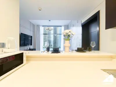 a kitchen with a vase of flowers on a counter at Luxury 2BR in Merano Tower & Stunning Canal Views in Dubai