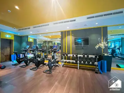 a gym with treadmills and elliptical machines at Luxury 2BR in Merano Tower & Stunning Canal Views in Dubai