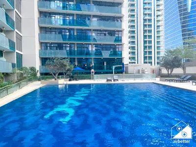 a large swimming pool in front of a building at Luxury 2BR in Merano Tower & Stunning Canal Views in Dubai