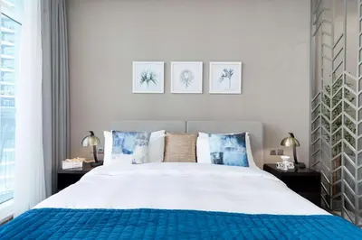 a bedroom with a bed and three pictures on the wall at Luxury Canal-View Studio in Dubai