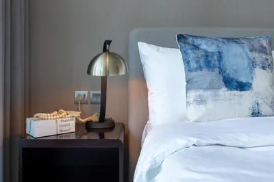 a bedroom with a bed and a lamp on a night stand at Luxury Canal-View Studio in Dubai