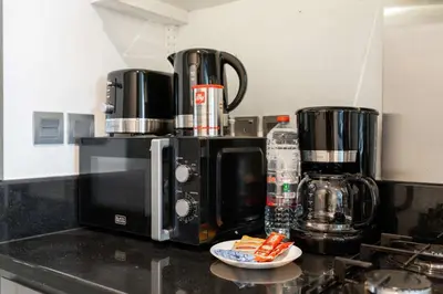 a kitchen counter with a coffee maker and a microwave at Luxury Canal-View Studio in Dubai