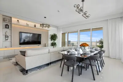 a dining room with a couch and a table and chairs at Iconic 3 Bedroom with Panoramic View in Grand Bleu in Dubai
