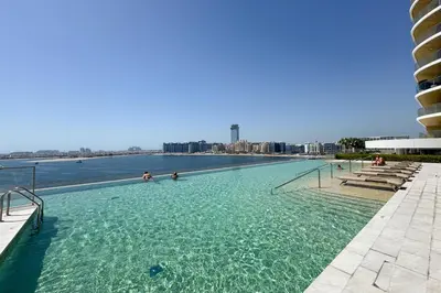 a large swimming pool with people in the water at Iconic 3 Bedroom with Panoramic View in Grand Bleu in Dubai