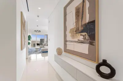 a hallway with white walls and art on the walls at Iconic 3 Bedroom with Panoramic View in Grand Bleu in Dubai