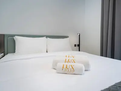 a bed with two pillows and towels on it at Contemporary Meydan Studio Escape in Dubai