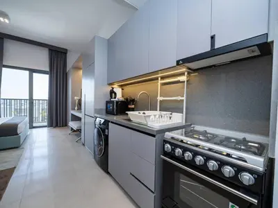 a large kitchen with a stove and a sink at Contemporary Meydan Studio Escape in Dubai