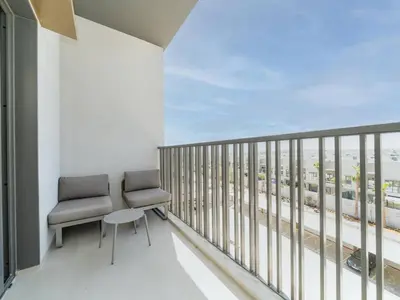 two chairs and a table on a balcony with a view at Contemporary Meydan Studio Escape in Dubai