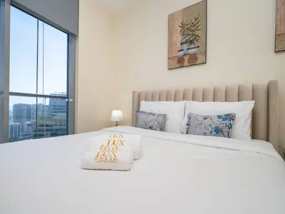 a bedroom with a large white bed with a window at Spacious 3 Bed Marina Haven with Waterfront Views in Dubai